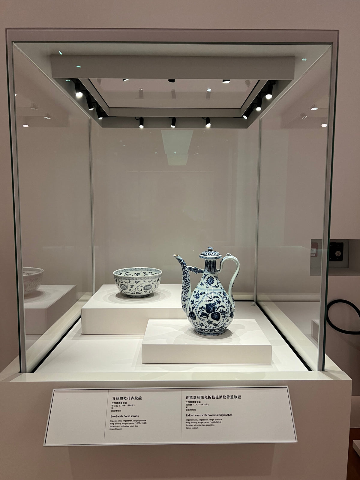Detail of miniature spotlights above ceramic objects in a glazed cabinet